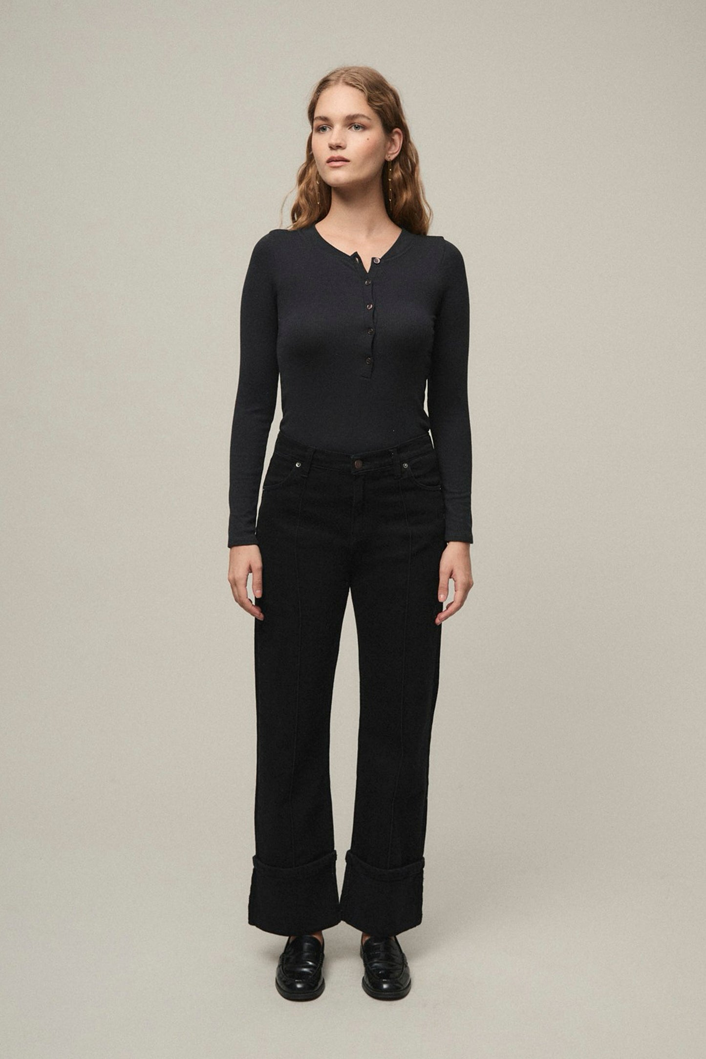 Woman wearing a black long-sleeve top and black pants Mi&co Pukas Surf Shop