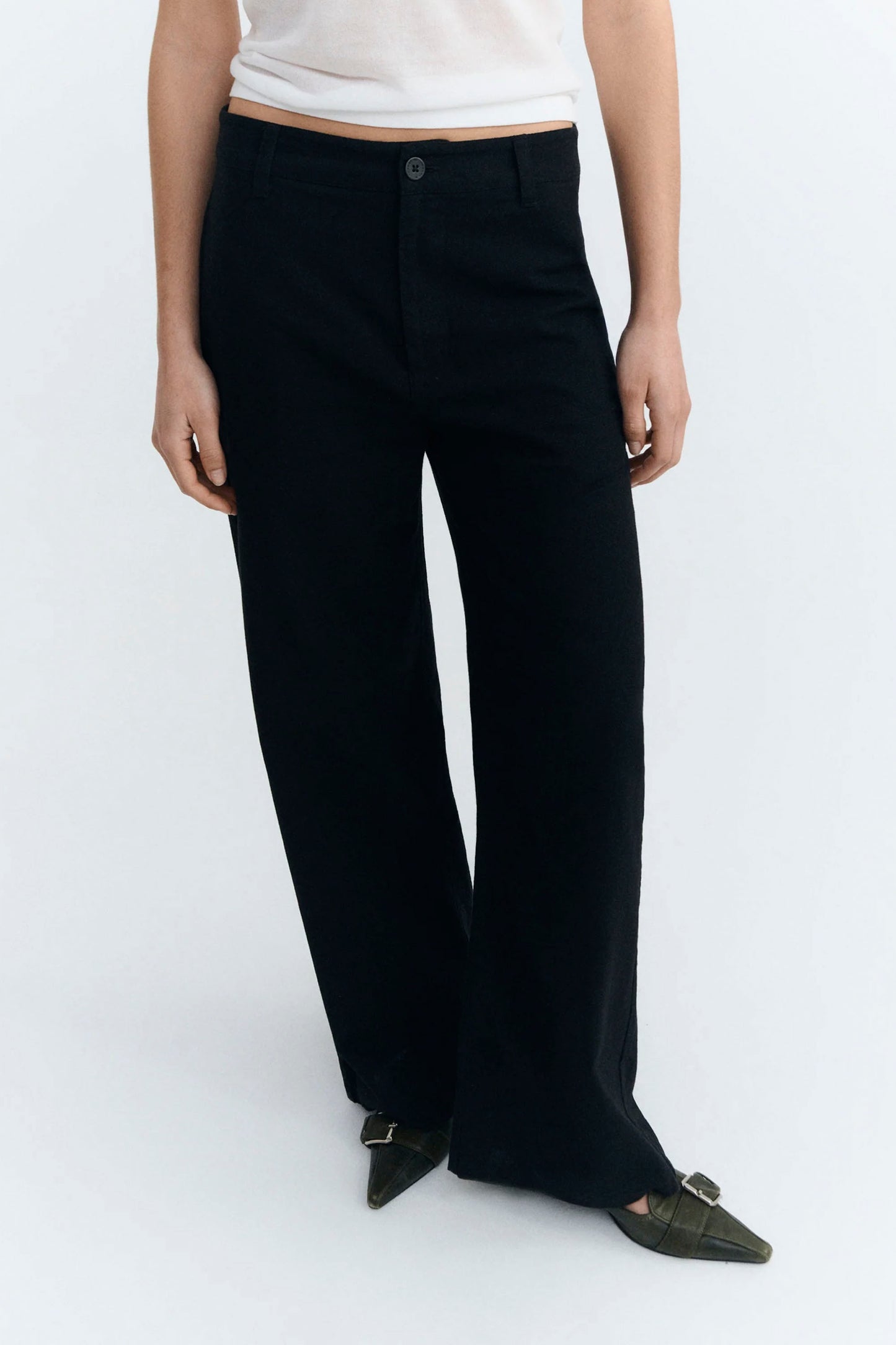 Person wearing black Thinking Mu pants  and a white top on a white background