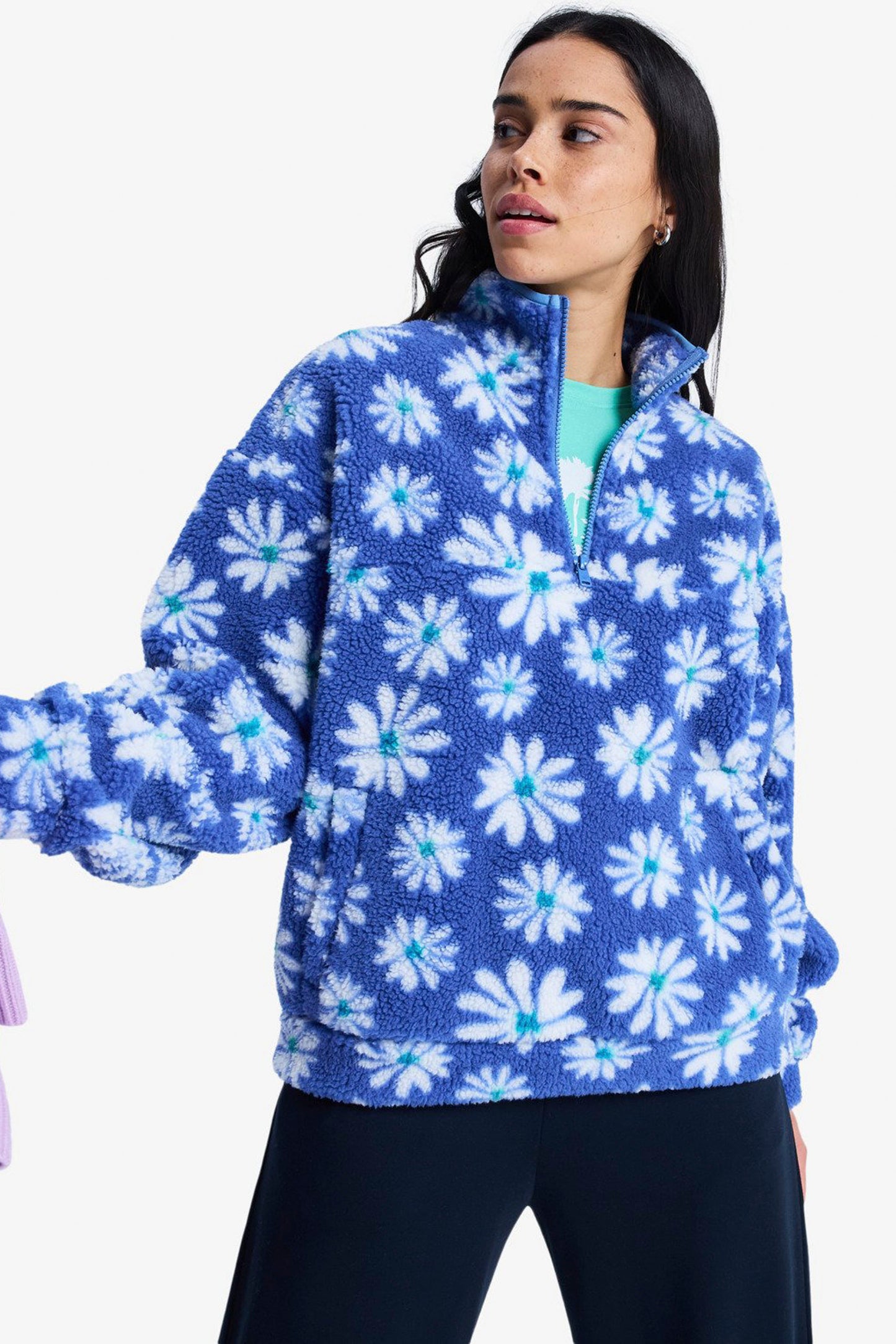 Woman wearing a blue floral patterned fleece jacket on a white background