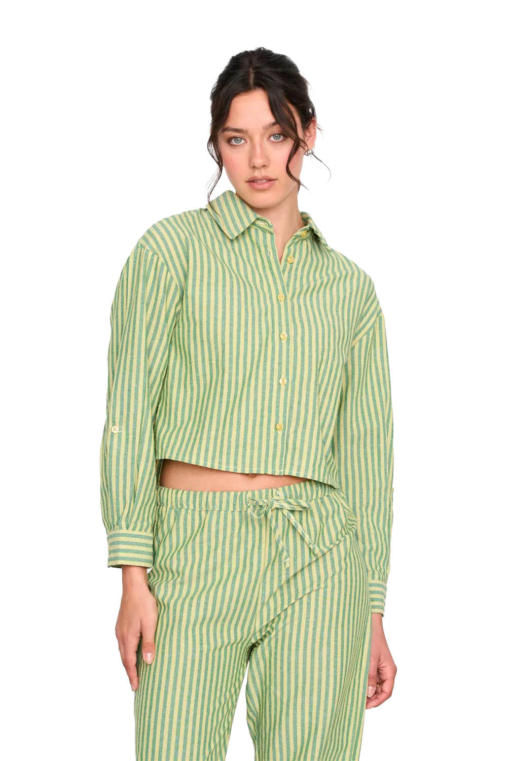 Woman wearing a green and white striped shirt and pants on a white background