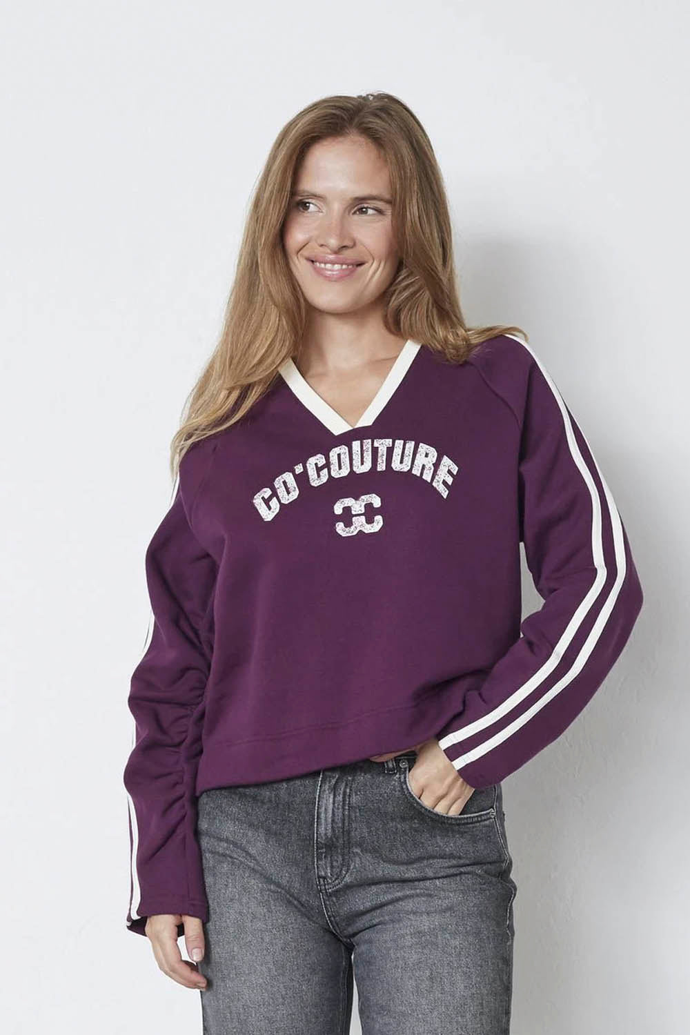 CO´COUTURE Batucc Coco V-Sweat in Plum – front view, woman wearing purple varsity sweatshirt with logo