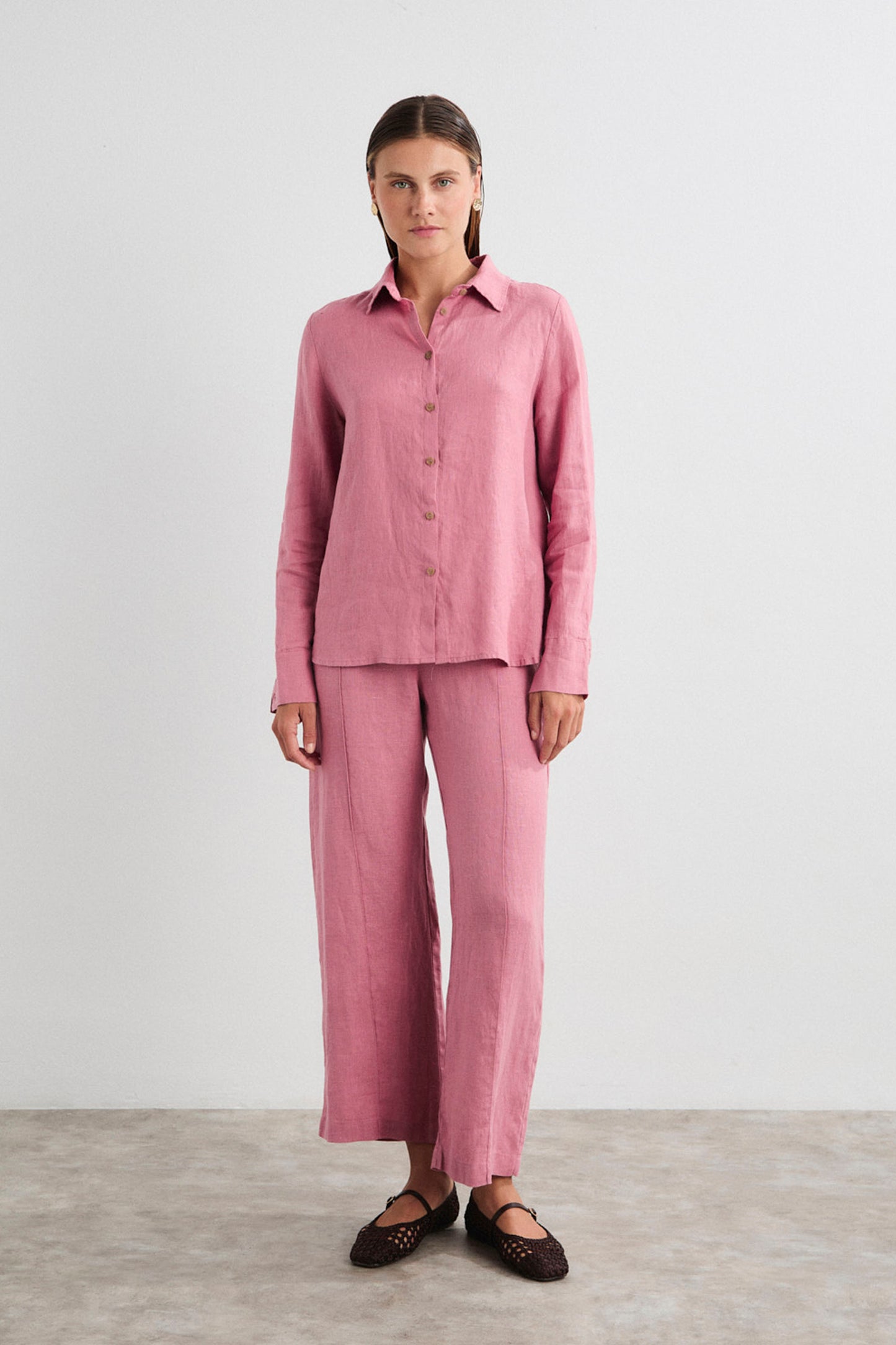 Woman wearing a pink pajama set against a white background