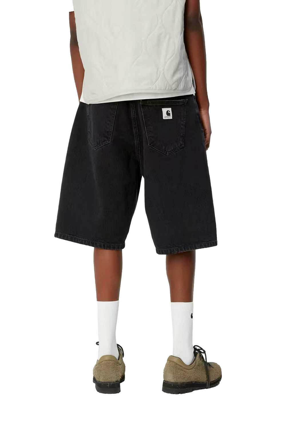 Person wearing black shorts, white socks, and brown shoes on a white background
