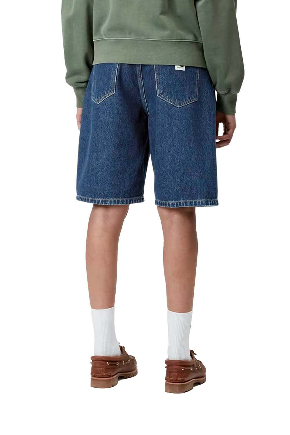 Person wearing blue denim shorts, a green sweatshirt, white socks, and brown shoes on a white background