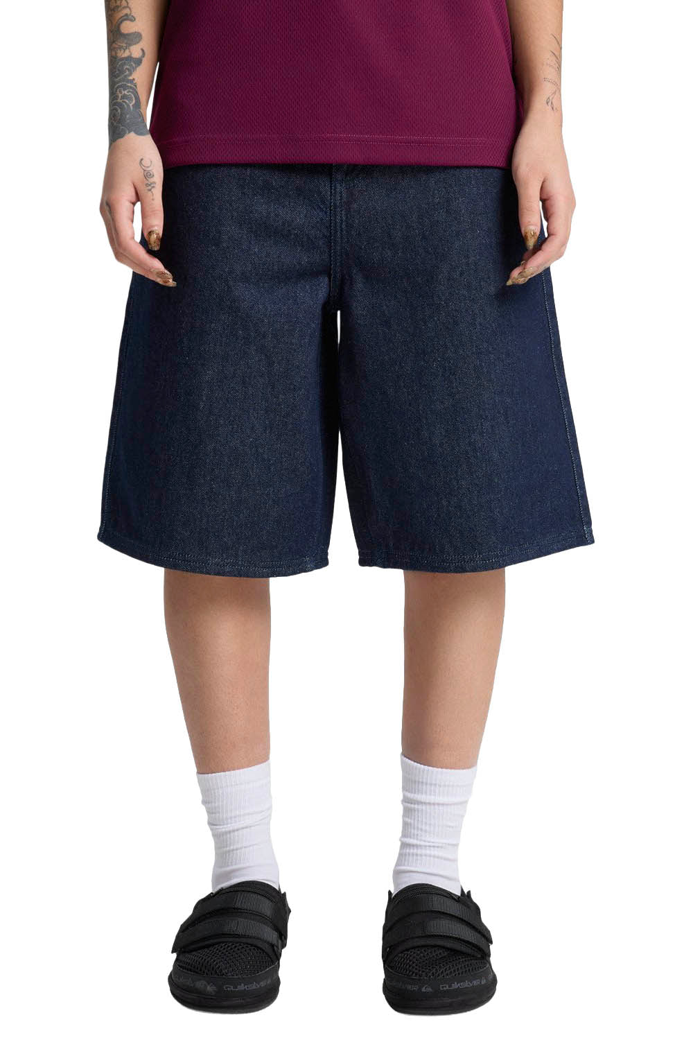 Person wearing dark denim shorts on a white background