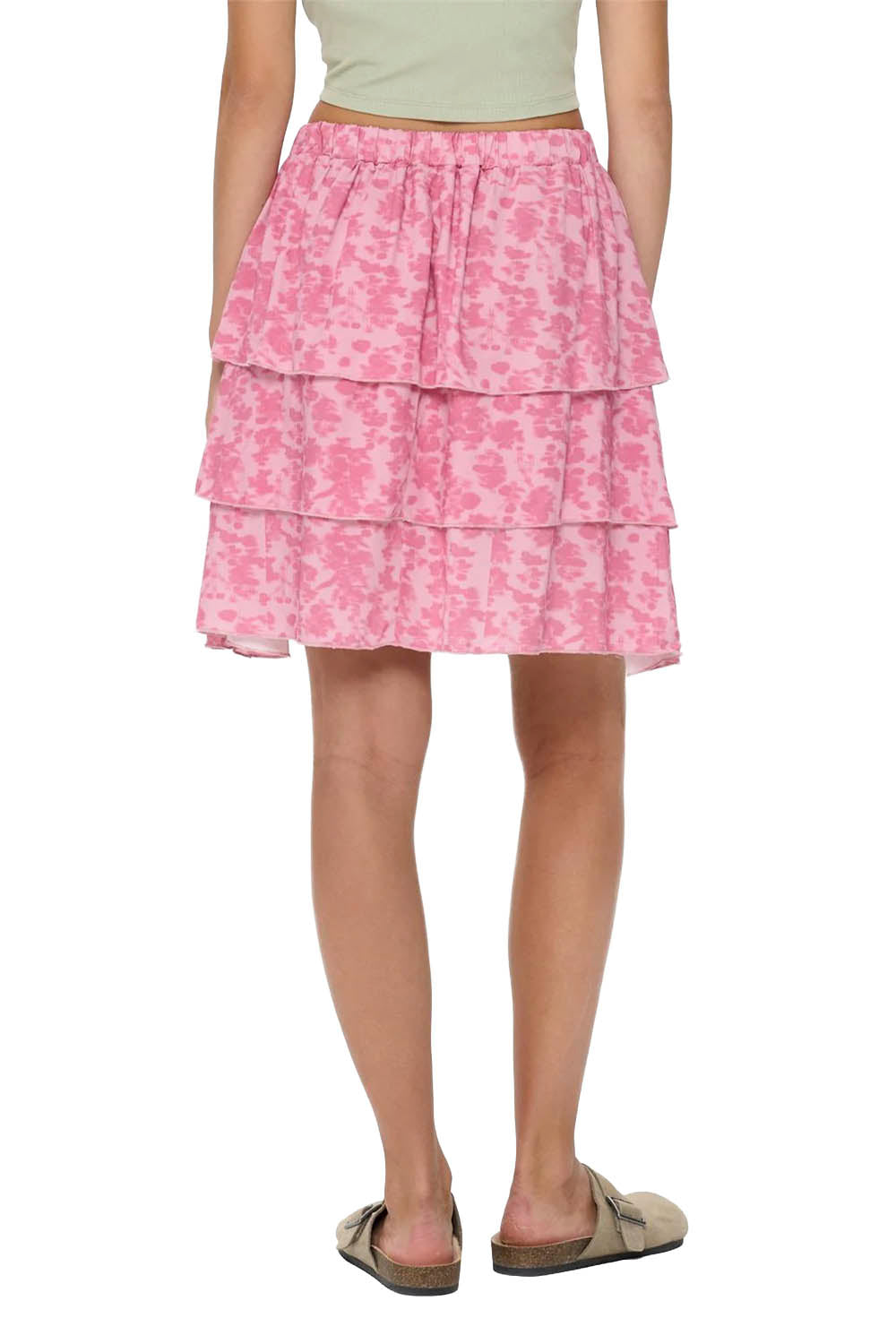 Pink tiered skirt worn by a person on a white background