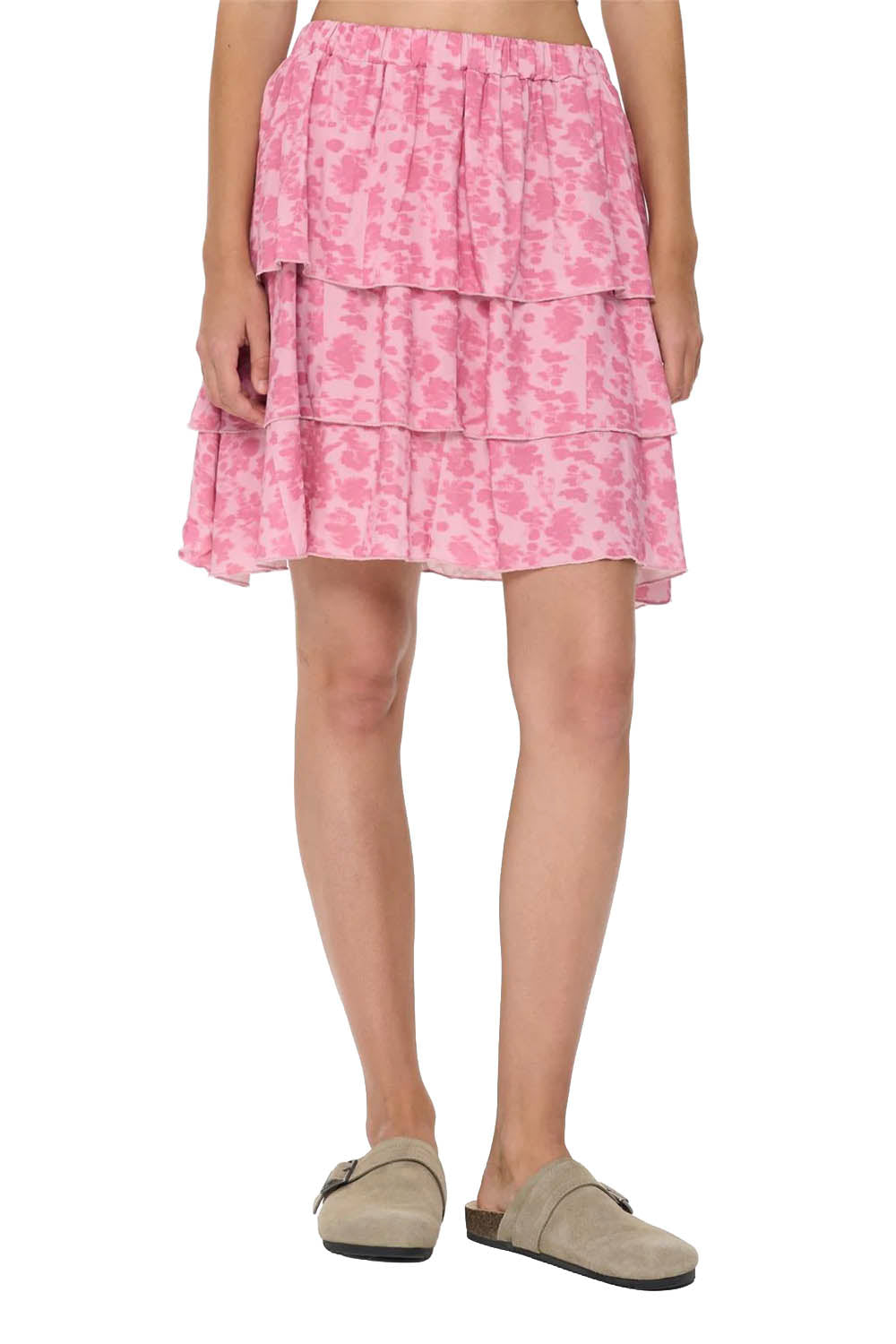 Pink tiered skirt worn by a person on a white background
