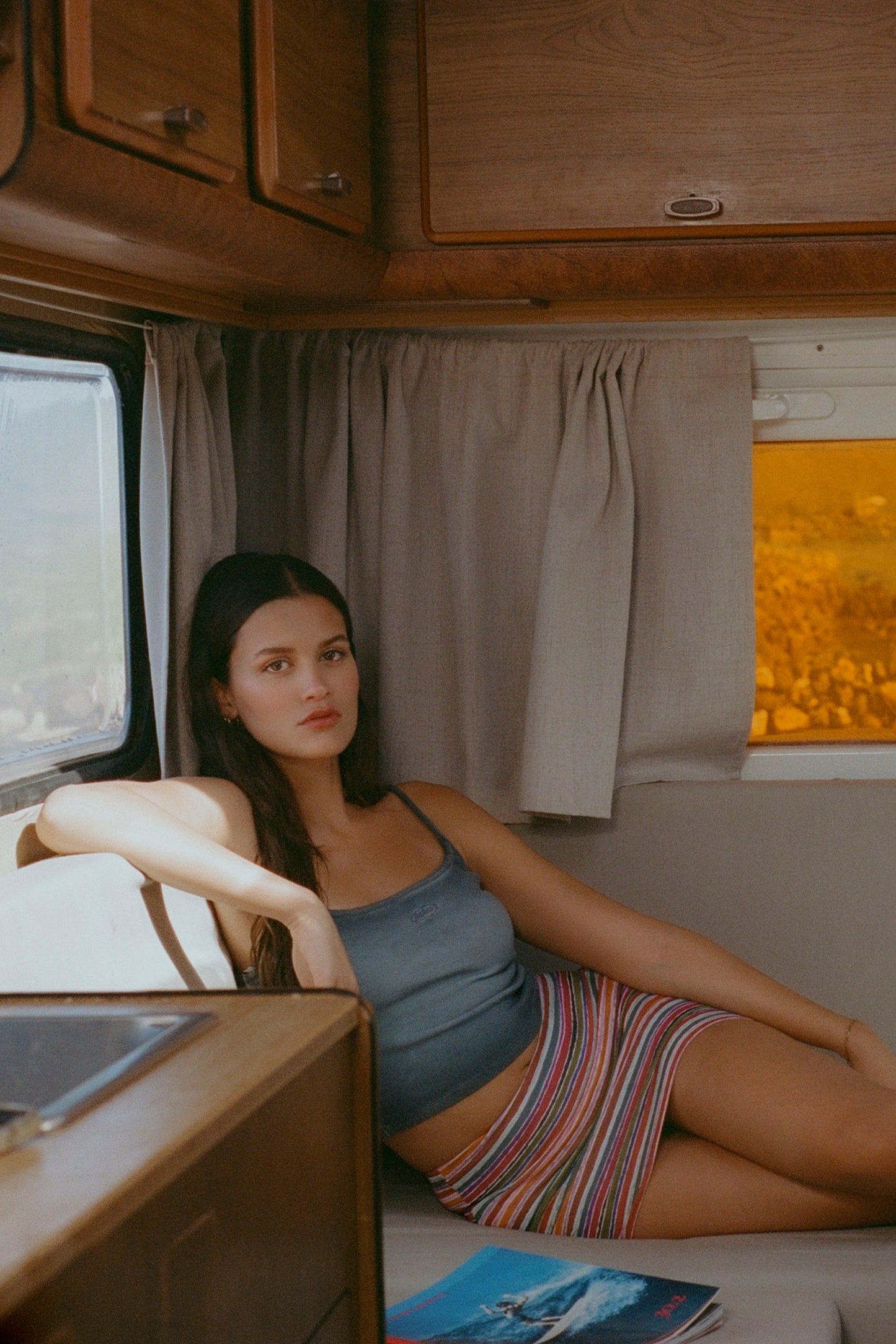 Woman sitting inside a vehicle with wooden interior and window view