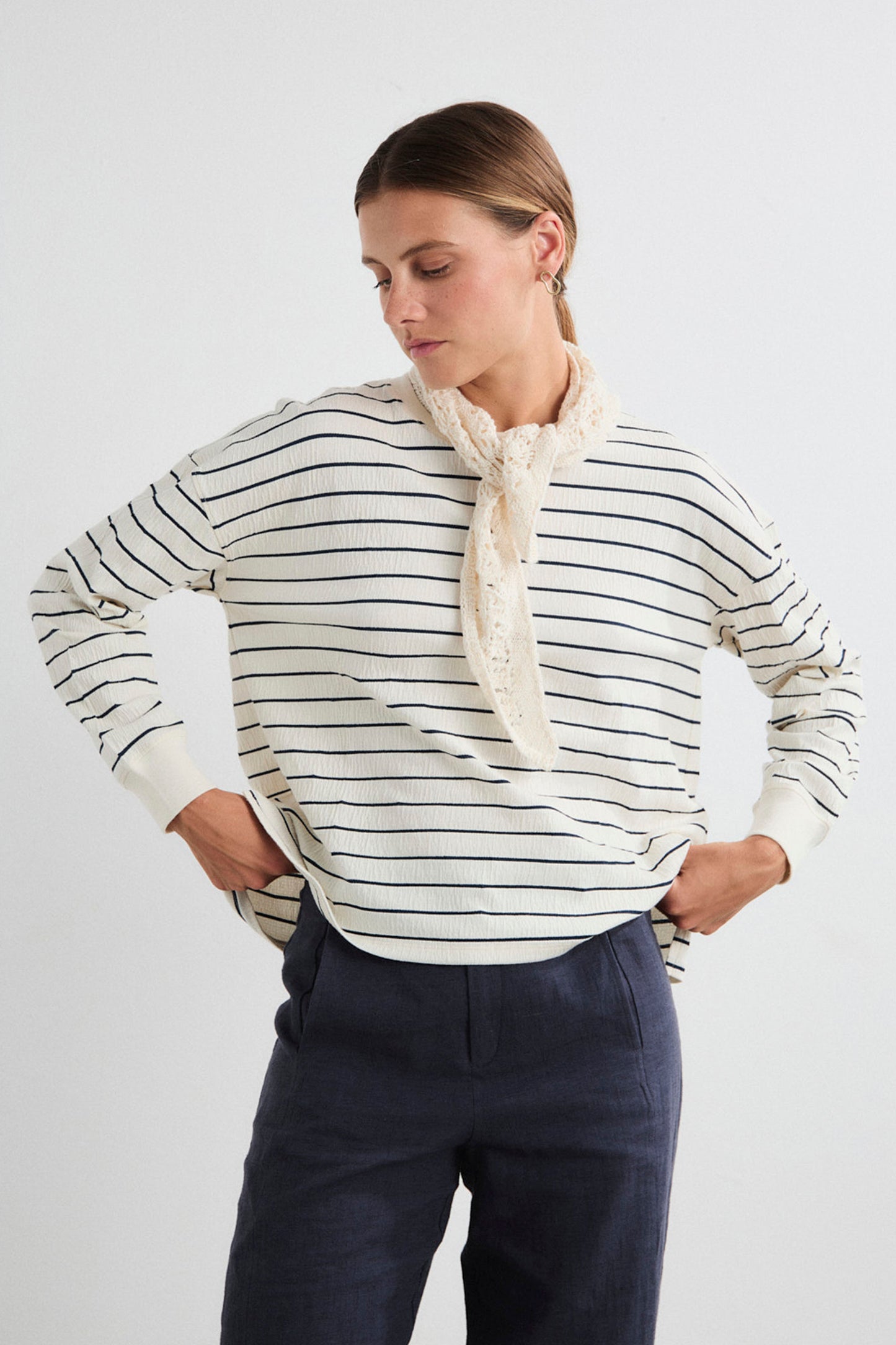 Woman wearing a striped Mus&Bombon Salana sweater and scarf on a white background