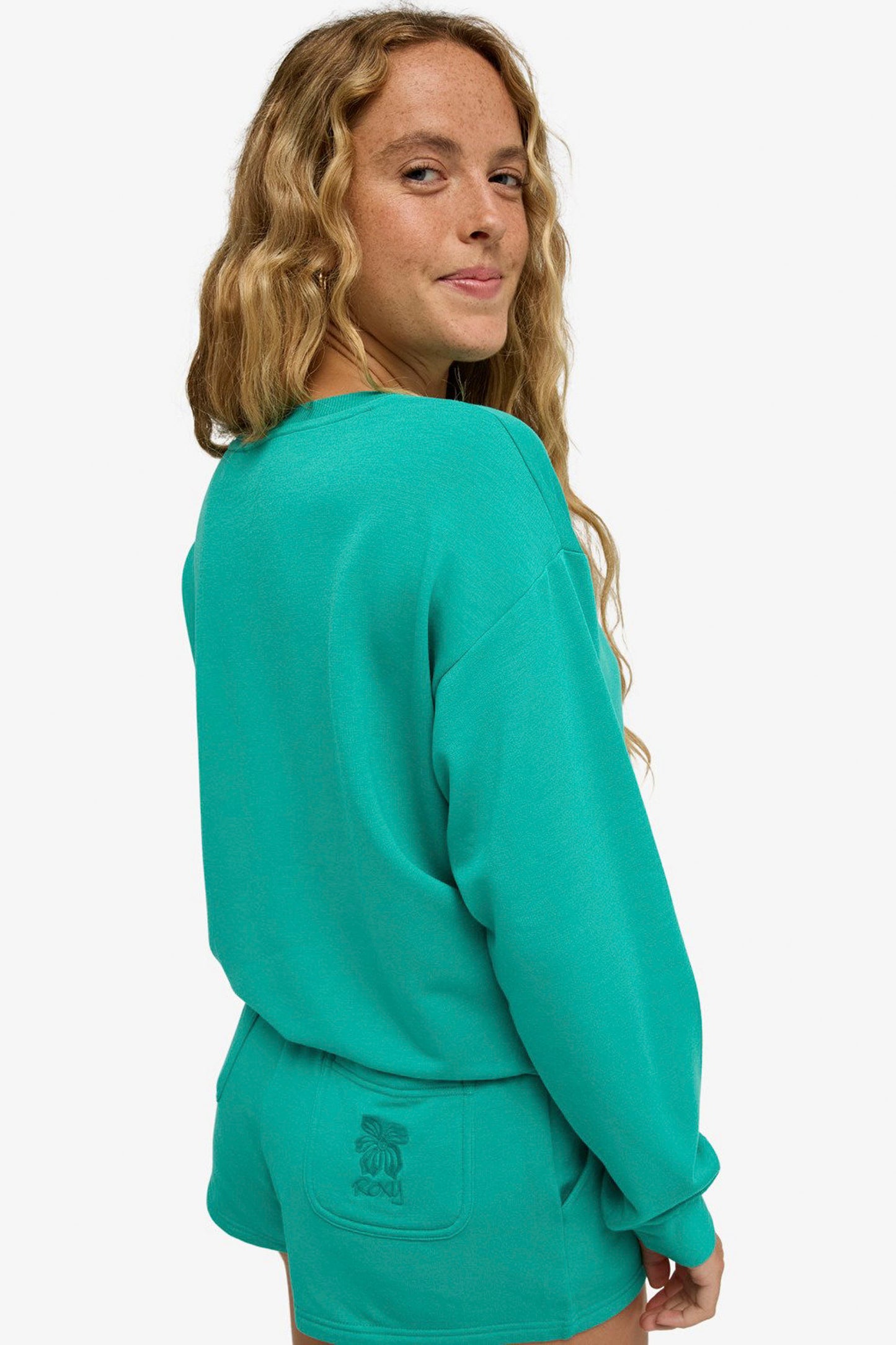 Person wearing a ROXY Surfing By Moonlight sweatshirt on a white background