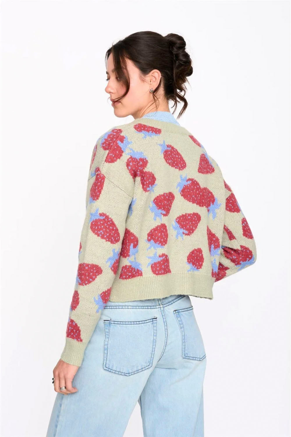 Woman wearing a patterned cardigan with a white background