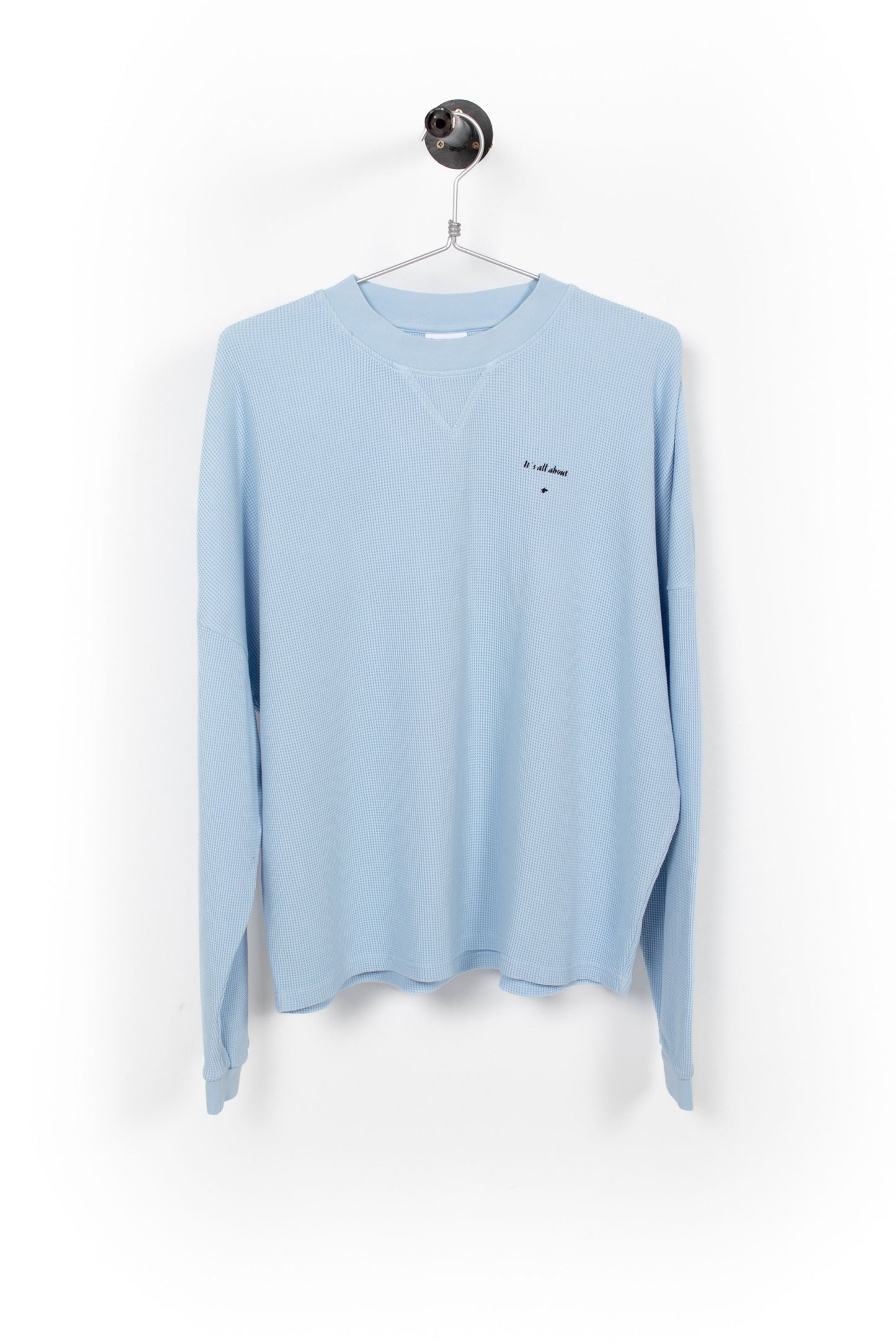 Light blue long-sleeve shirt on a hanger against a white background