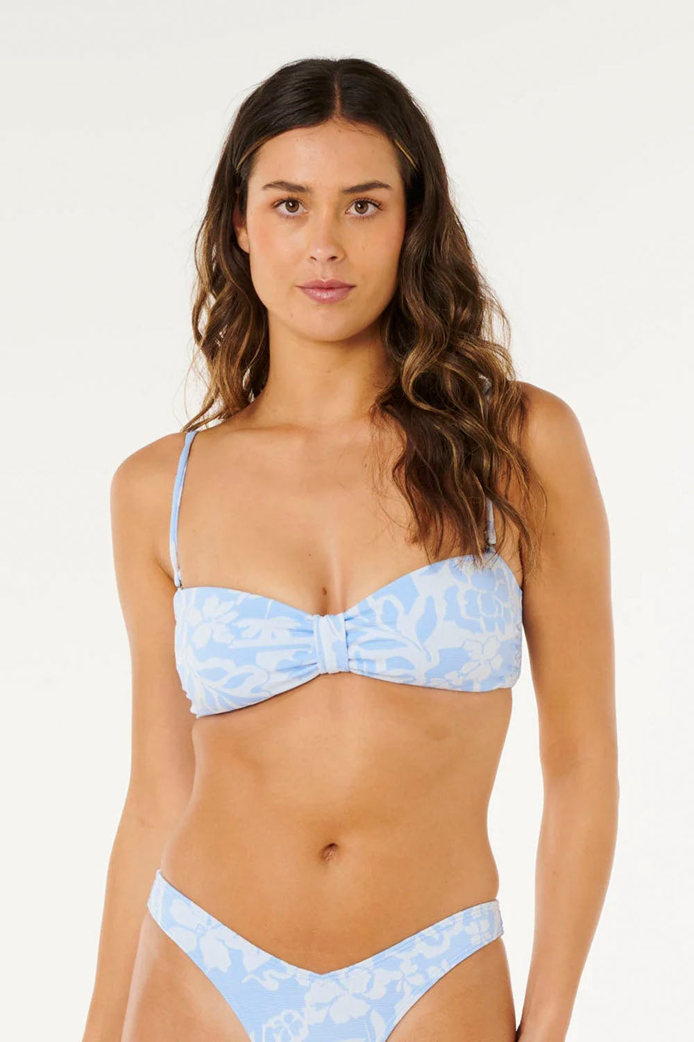 Woman wearing a light blue floral bikini against a white background