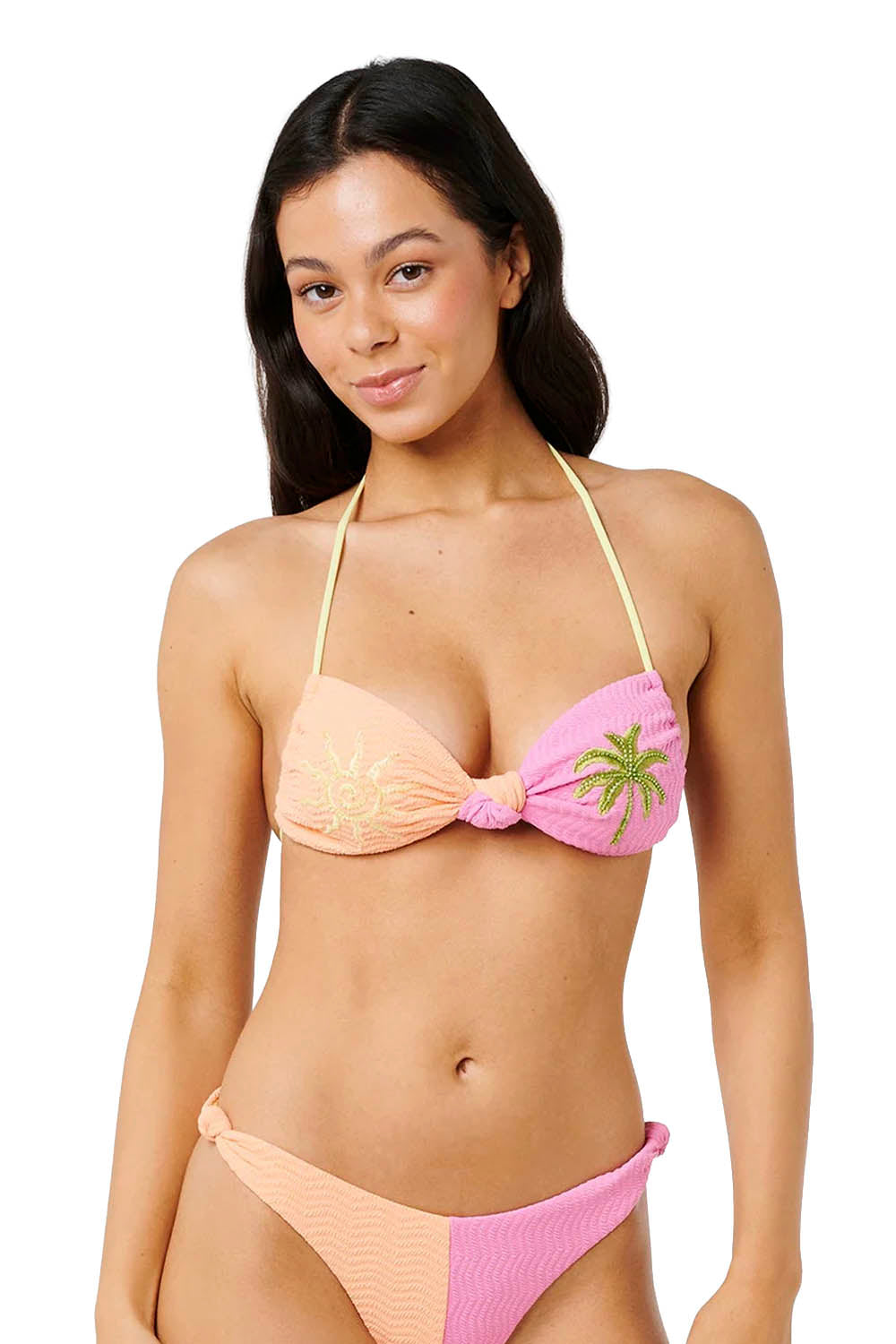 Woman wearing a pink and peach bikini with a tropical leaf design on a white background