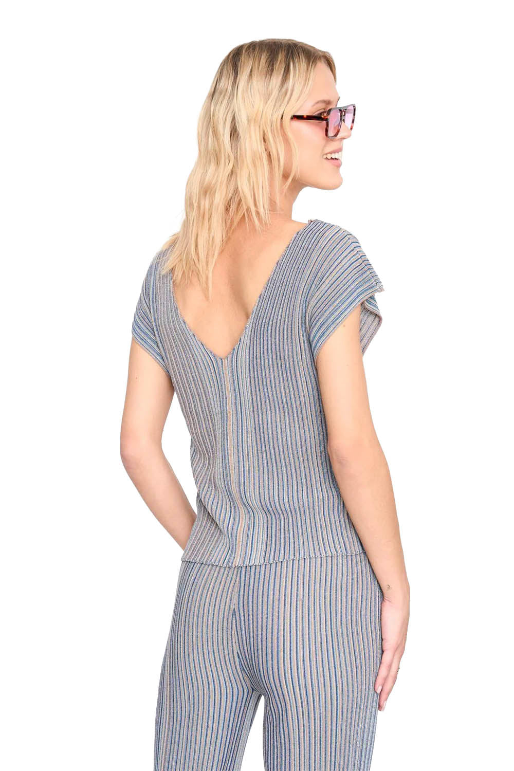 Woman wearing a blue and brown striped jumpsuit on a white background