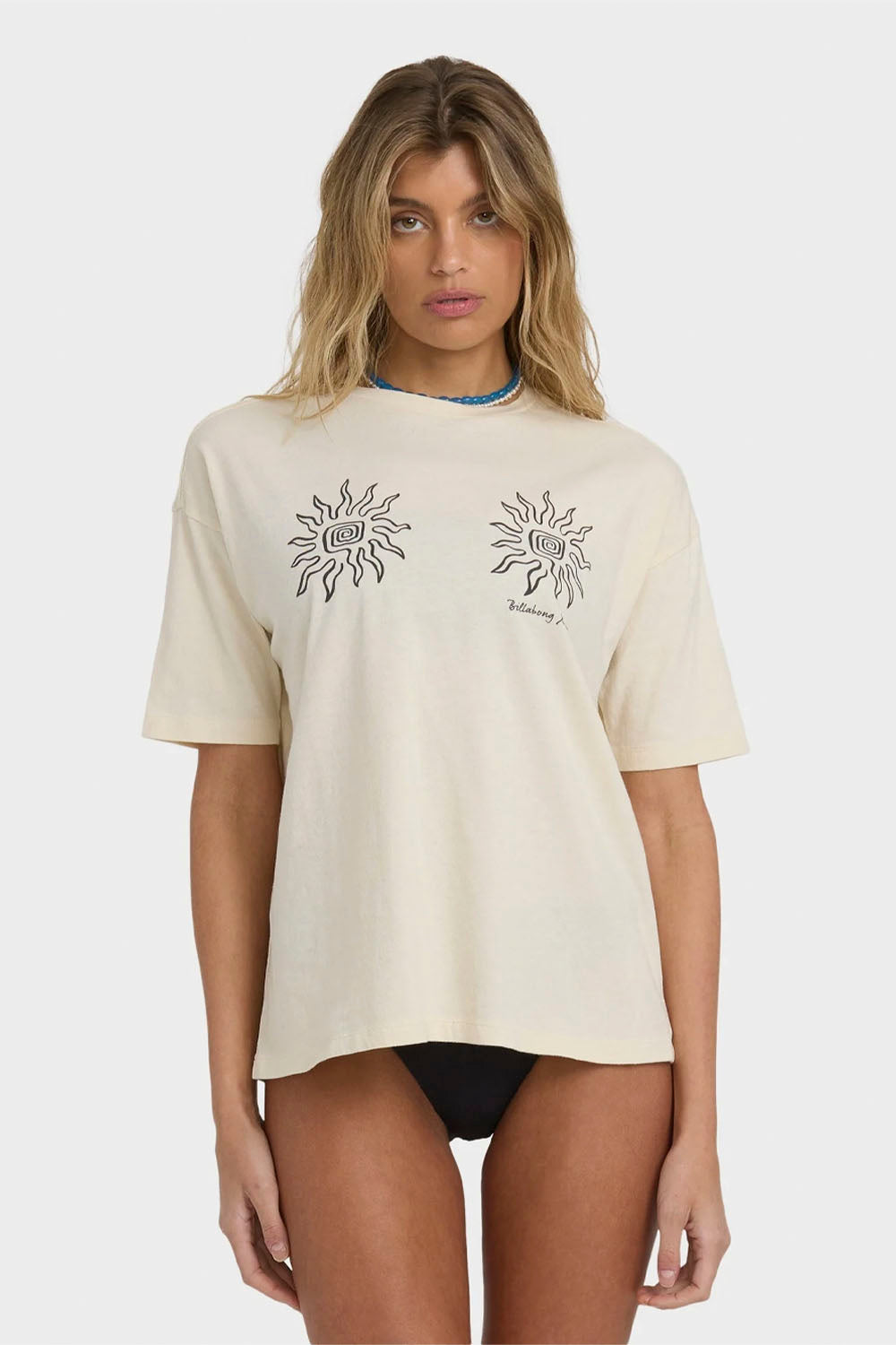 Woman wearing a beige t-shirt with sun designs on a white background