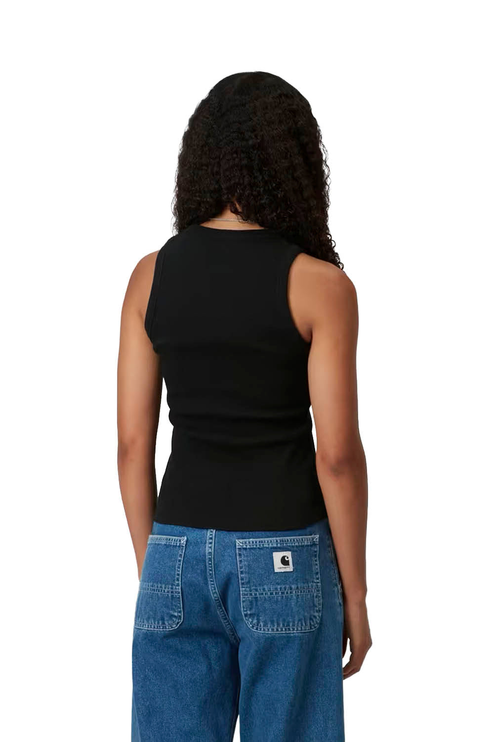 Person wearing a black sleeveless top and blue jeans on a white background