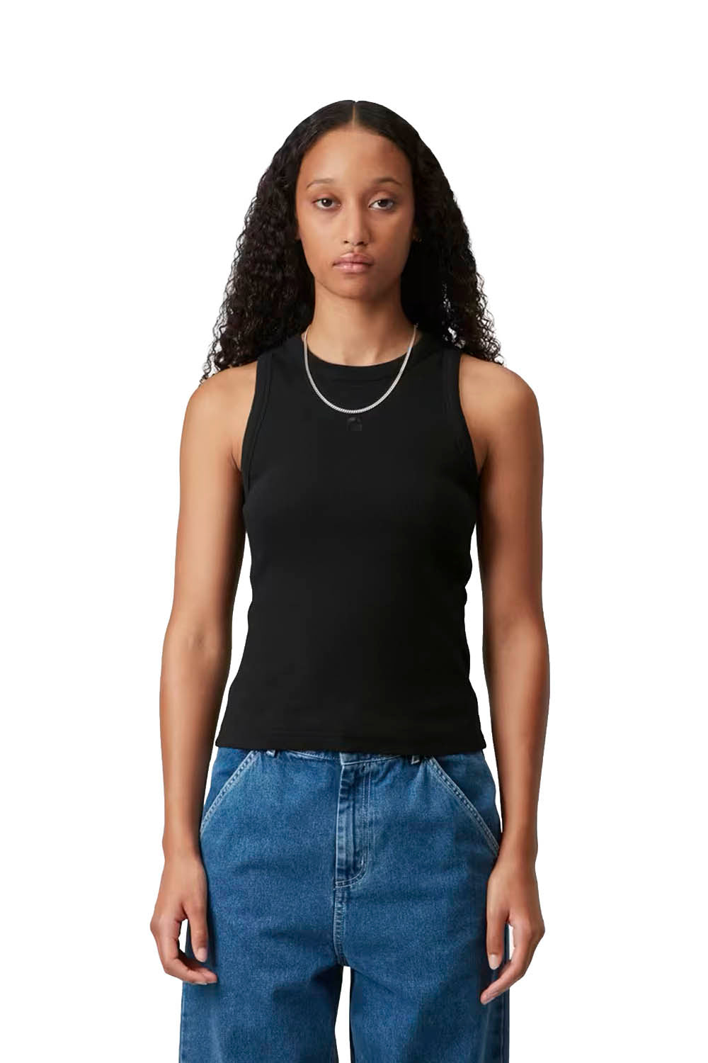 Woman wearing a black sleeveless top and blue jeans on a white background