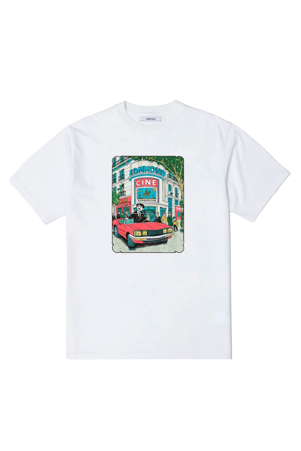 A white short-sleeve crewneck t-shirt featuring a colorful graphic print on the front depicting a red convertible car parked in front of a building with a 'CINE' sign.