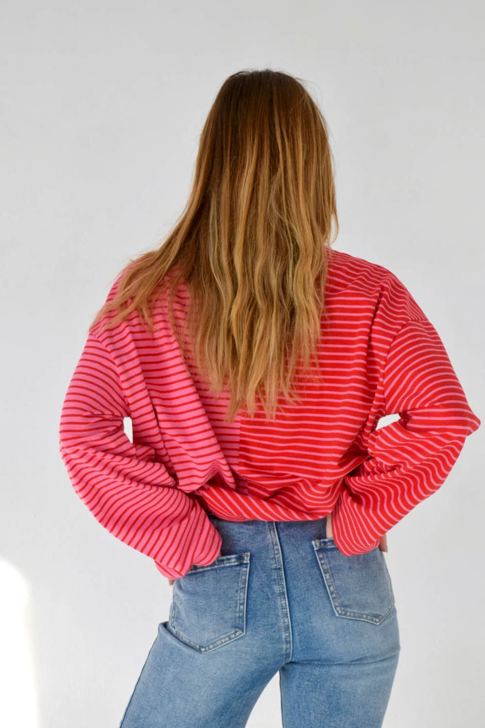 Mind Traveler BCN Mariona Long Sleeve Tee Red Pink — women's relaxed-fit bicolour striped long sleeve tee with red ribbed crew neck and Mind Traveler BCN label at hem, styled with blue jeans