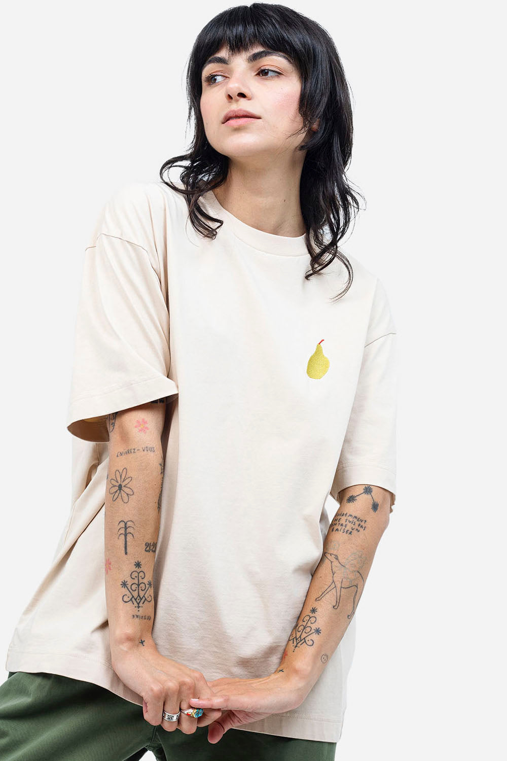 Person wearing a plain white t-shirt with a small yellow graphic on a white background