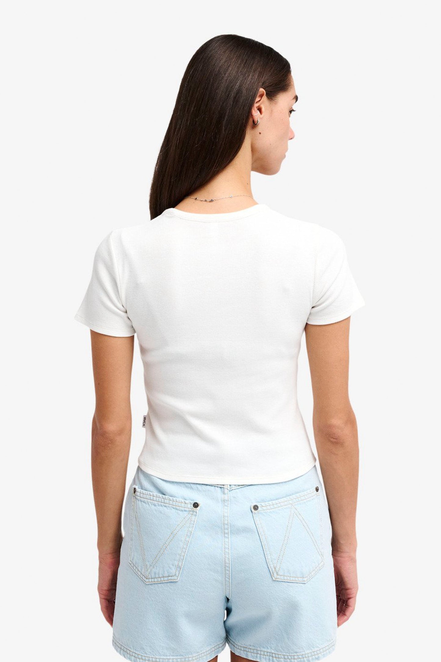 Woman wearing a RVCA Smiley Tank and light blue shorts on a white background