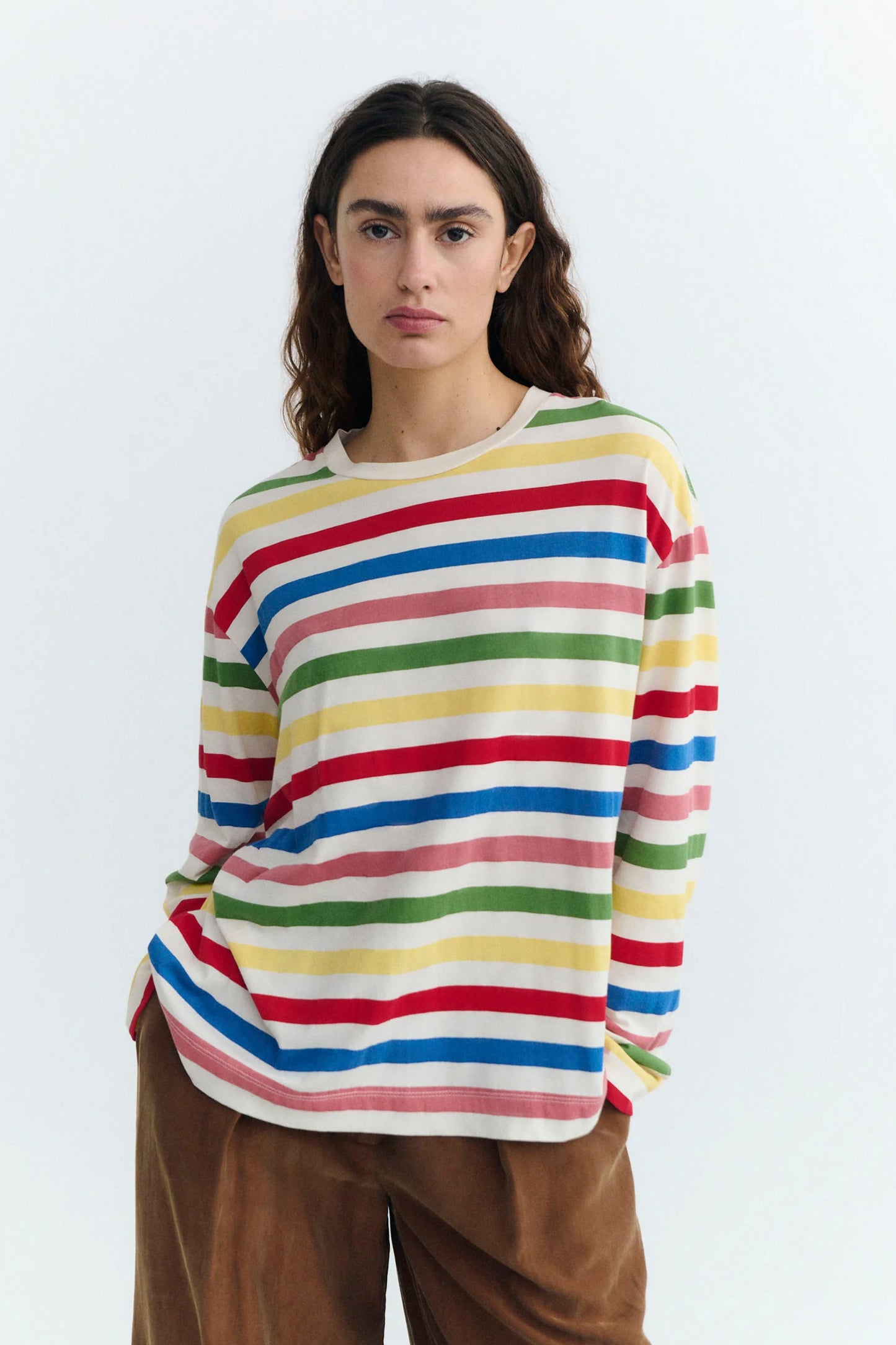 Person wearing a colorful striped Thinking Mu sweater on a white background