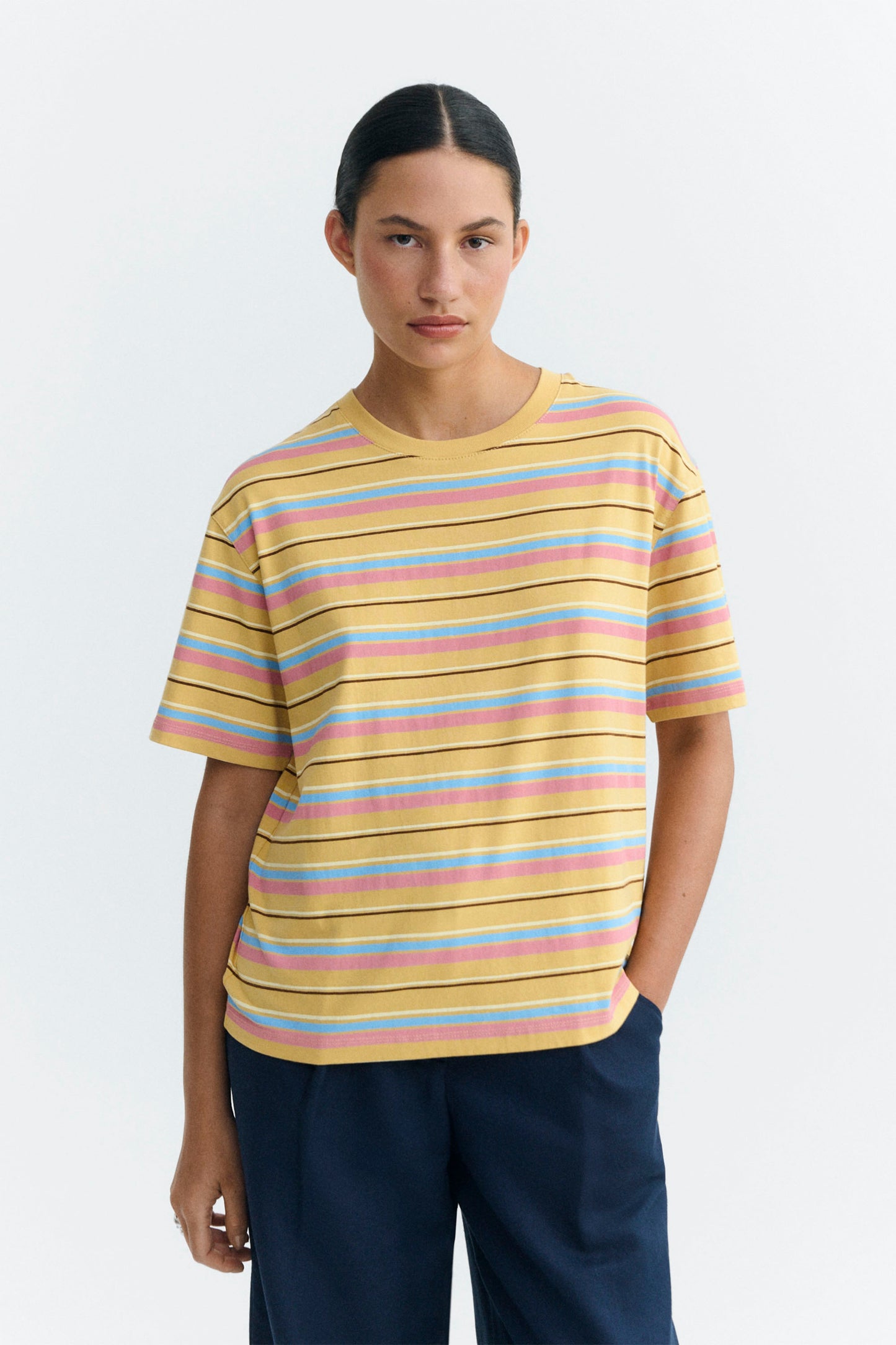 Woman wearing a Multicolored Thinking Mu striped t-shirt on a white background