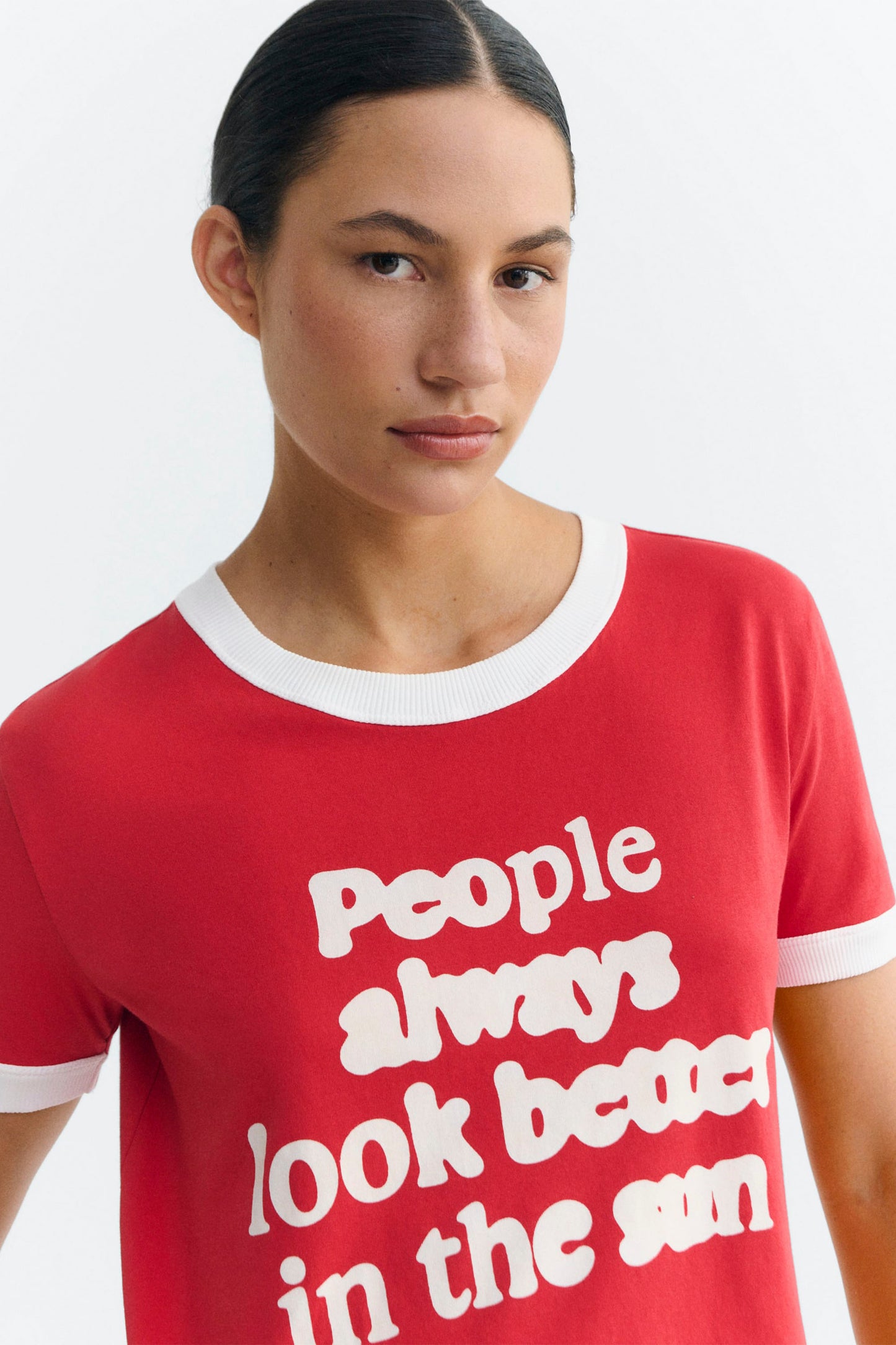 Woman wearing Red Thinking Mu Zowie t-shirt with white text on a white background