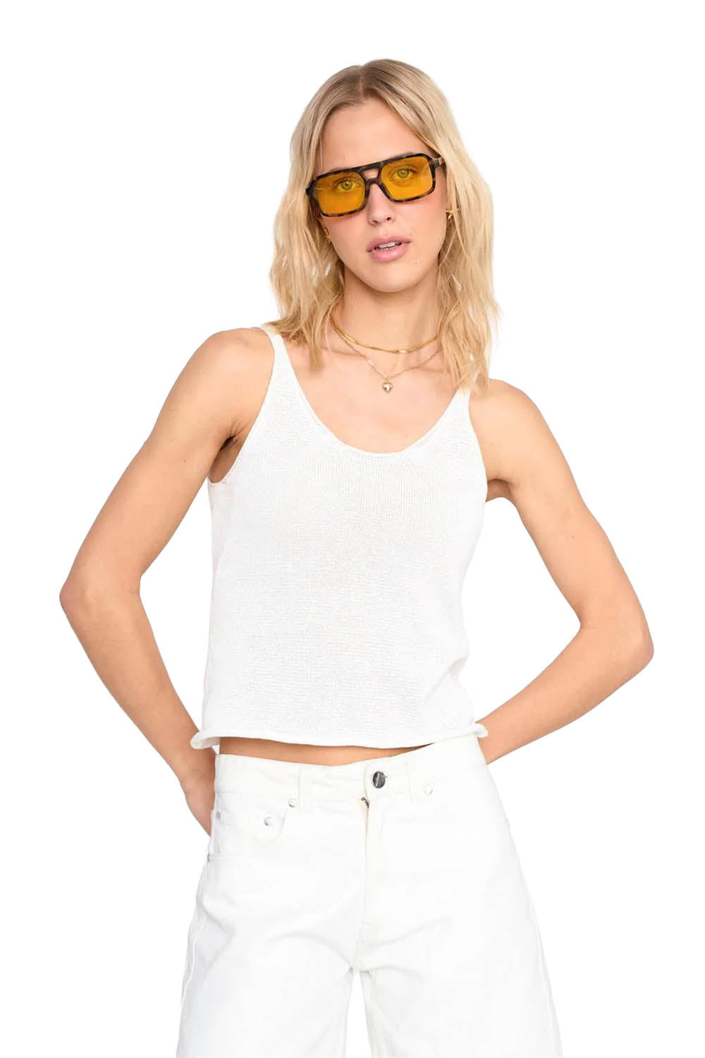 Woman wearing a white tank top and sunglasses on a white background
