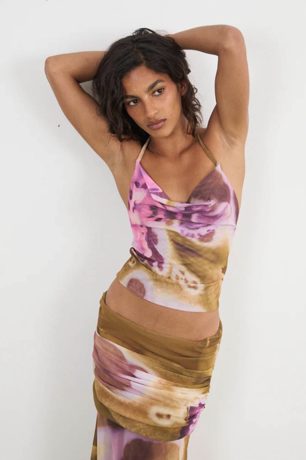 Woman wearing a colorful dress with a tie-dye pattern on a white background