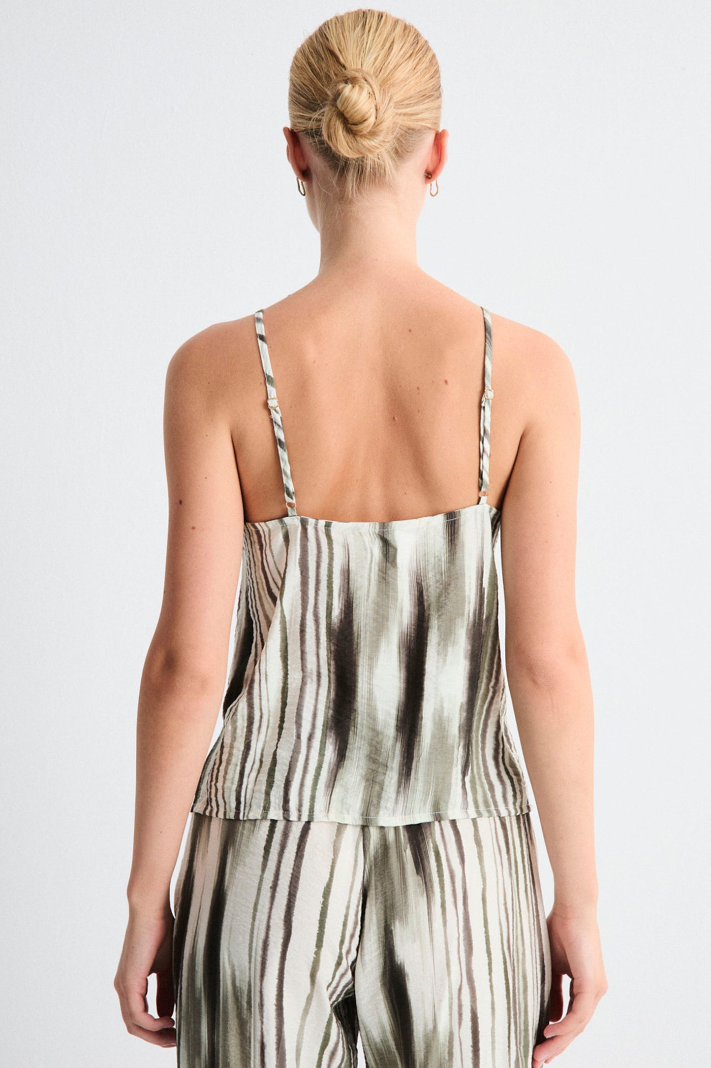 Person wearing a tie-dye top and pants set on a white background