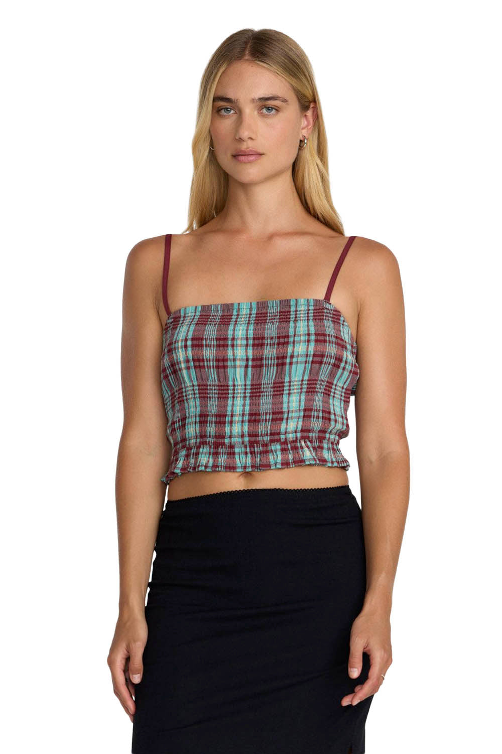 Woman wearing a plaid top and black skirt on a white background