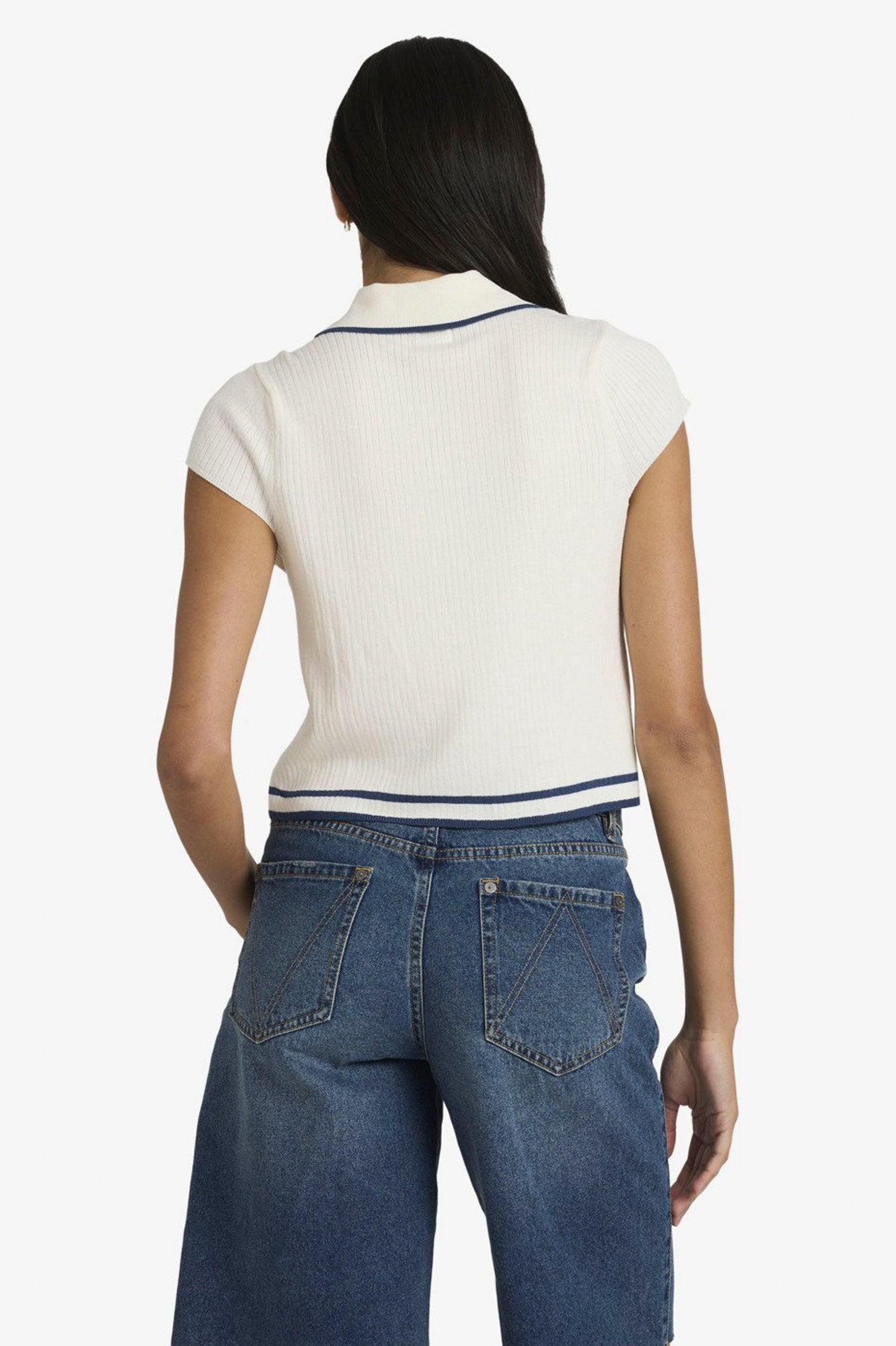 Person wearing a white RVCA Jules Sweater Top and blue jeans on a white background