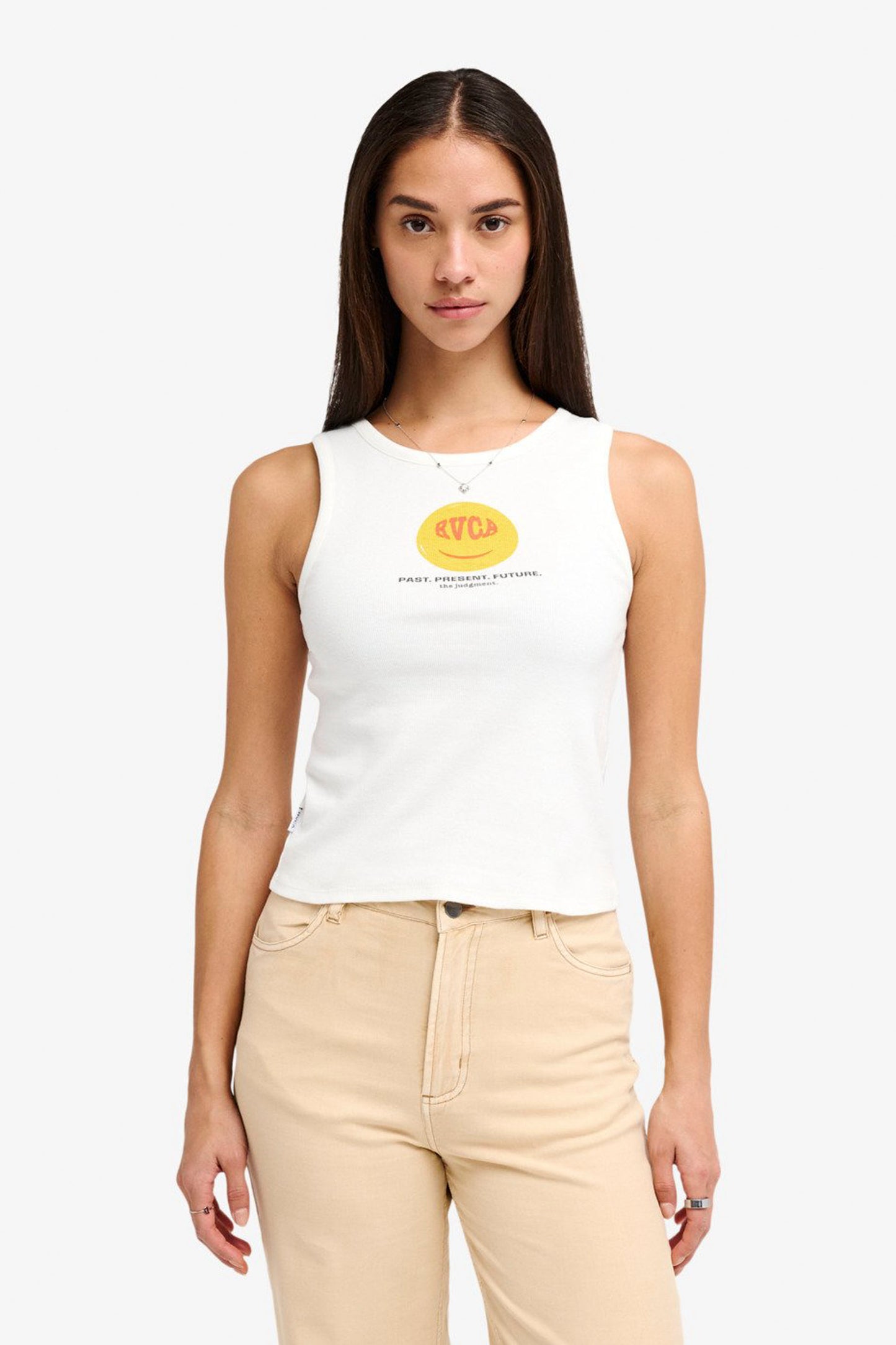 Woman wearing a white RVCA Smiley Tank with a yellow logo on a white background