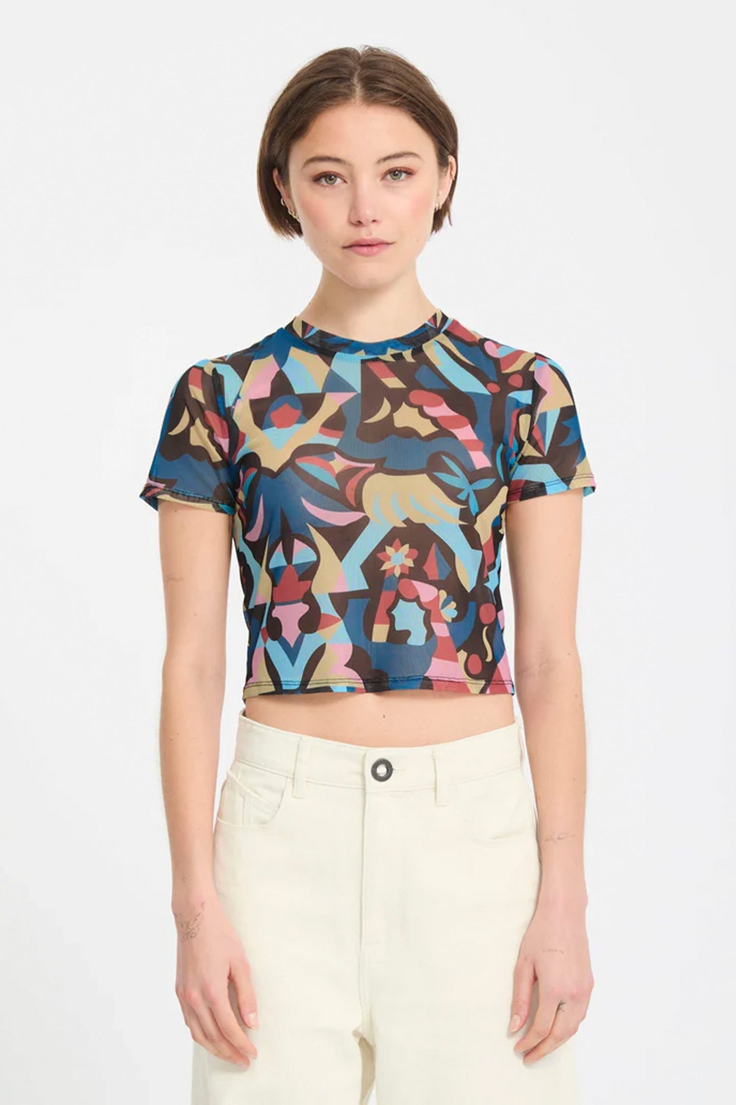 Woman wearing a colorful Volcom Fa Bruno Lukas crop top on a white background