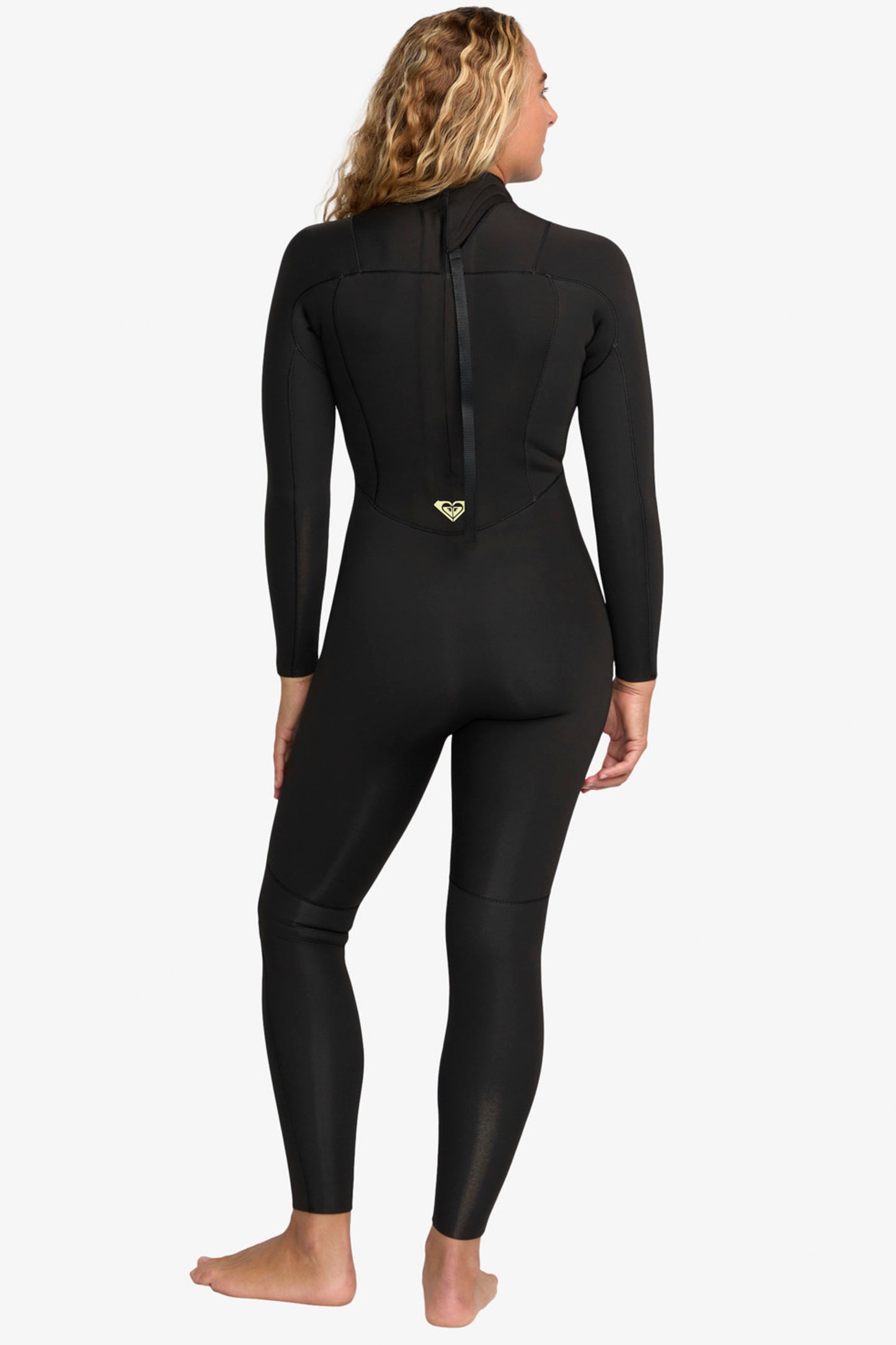 Woman wearing a black Roxy Prologue 3/2 mm wetsuit on a white background